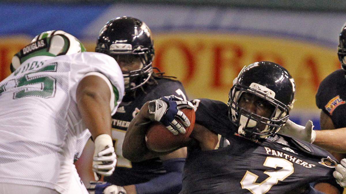 Florida International University's Richard Leonard returns a first quarter interception as Marshall's Eric Frohnapfel tackles him during the Beef 'O' Brady Bowl at Tropicana Field in Saint Petersburg, Dec. 20, 2011.