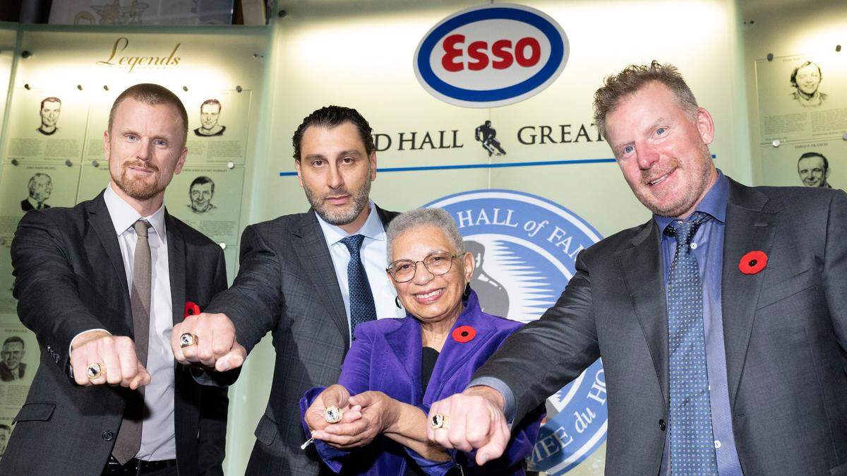 Daniel Sedin, left to right, Roberto Luongo, Herb Carnegie’s daughter Bernice Carnegie, and Daniel Alfredsson pose with their rings during a ceremony to celebrate the latest inductees into the ‘Hockey Hall of Fame’ at an event in Toronto, Friday, Nov. 11, 2022. (Chris Young/The Canadian Press via AP)