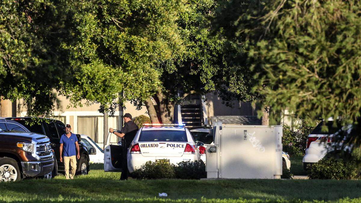 Police continue to work at the scene of a hostage standoff where a police officer was shot Monday morning, June 11, 2018, in Orlando. Police said a man suspected of battering his girlfriend wounded a police officer late Sunday and barricaded himself inside an apartment with several young children. (Jacob Langston/Orlando Sentinel via AP)