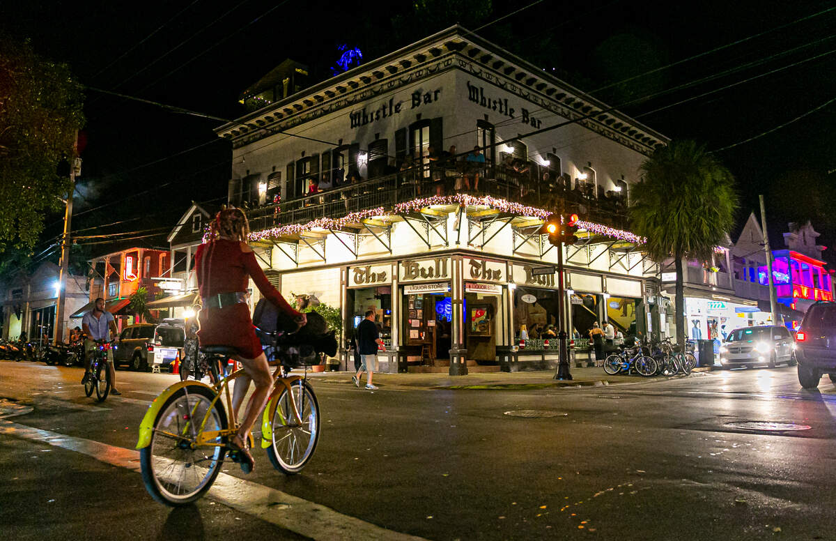 A biker makes her way past The Bull in Key West, Florida on Friday, December 10, 2021.
