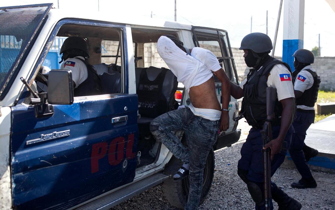 In this Dec. 10, 2018, photo, police arrest an alleged gang member whom residents of La Saline slum identify as one of the perpetrators of the massacre in their slum of Port-au-Prince, Haiti. The Nov. 13 massacre revealed a startling degradation of security in Haiti since U.N. peacekeepers decided to end their mandate because conditions had supposedly improved.