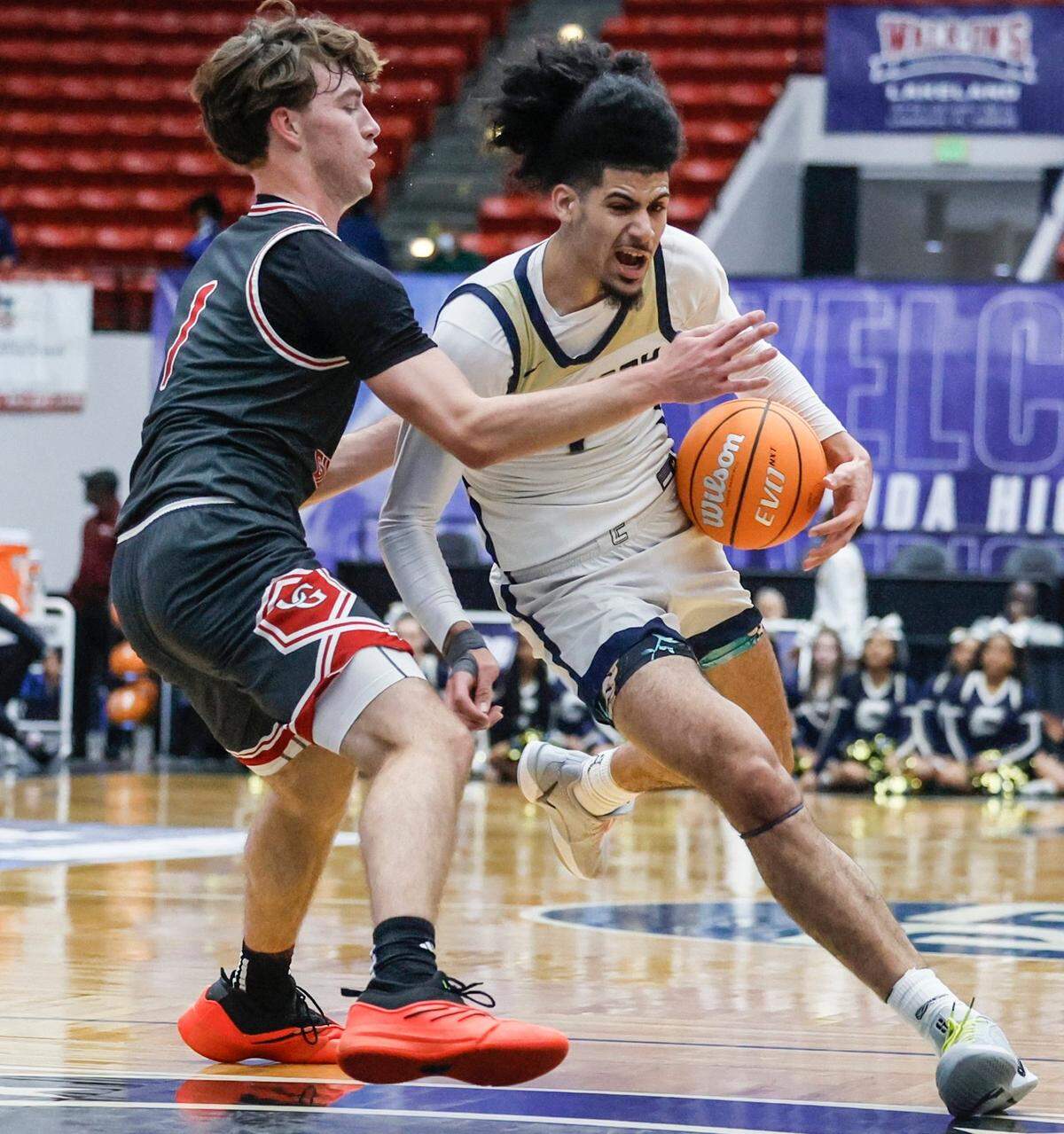 Calvary Christian Academy’s Shon Abaev (1) drives the ball as Cardinal Gibbons’ Tao Schreiber (1) defends in the first half during boys 3A basketball semifinal game of the Florida High School State Championships.