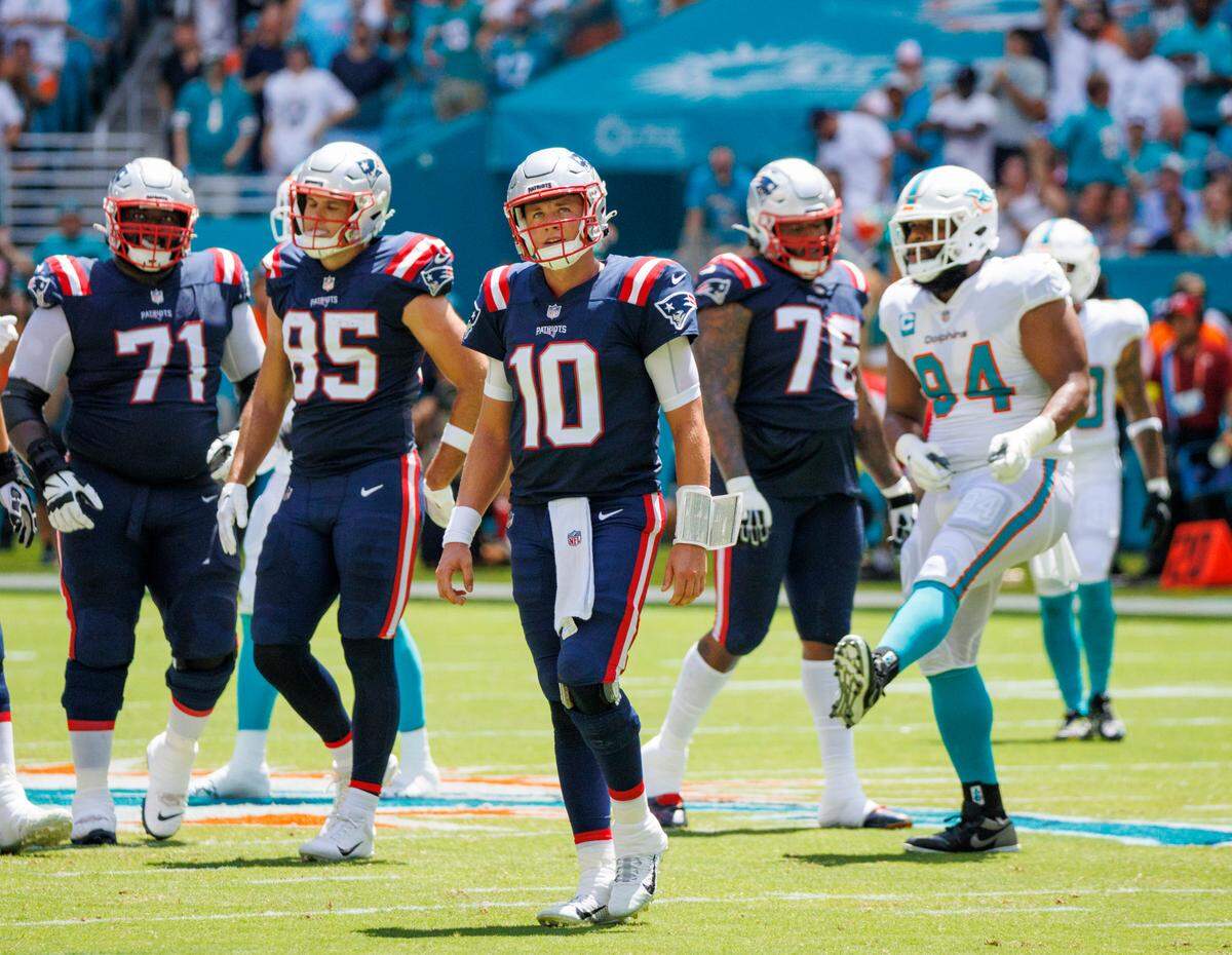 New England Patriots quarterback Mac Jones (10) reacts after a play during first quarter of an NFL football game against the Miami Dolphins at Hard Rock Stadium on Sunday, September 11, 2022 in Miami Gardens, Florida.