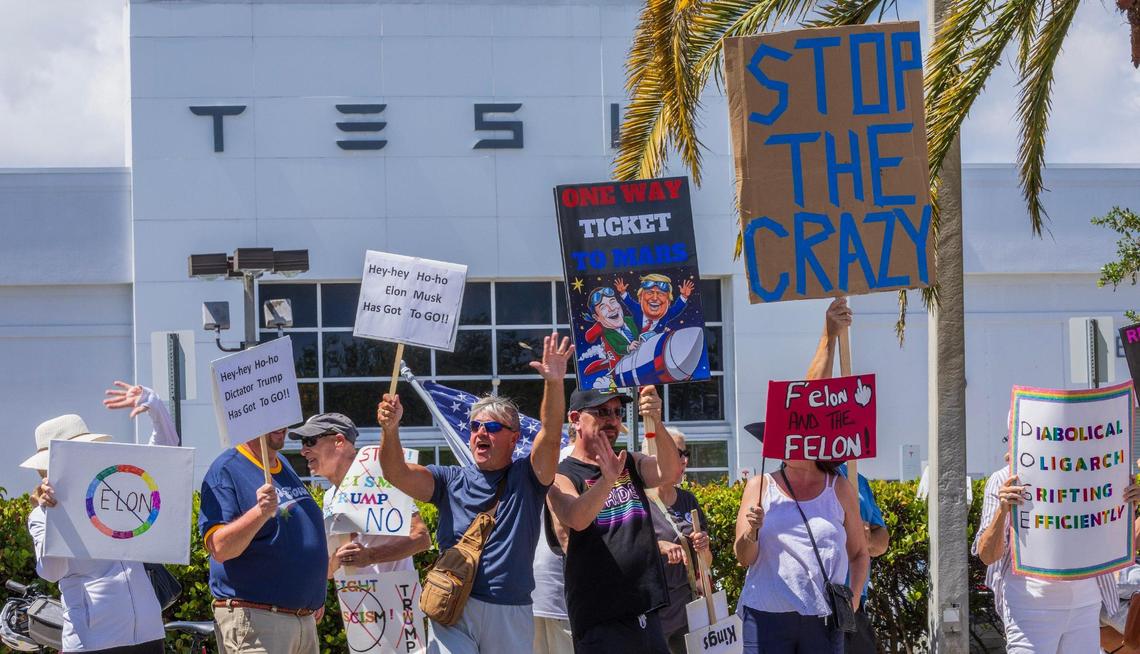 A group of “outraged” people protested in front of the Fort Lauderdale Tesla Showroom against the recent actions of President Donald Trump administration, in which Elon Musk now plays a key role — including mass layoffs, the removal of federal programs and funding for medical research, on Saturday March 15, 2025.