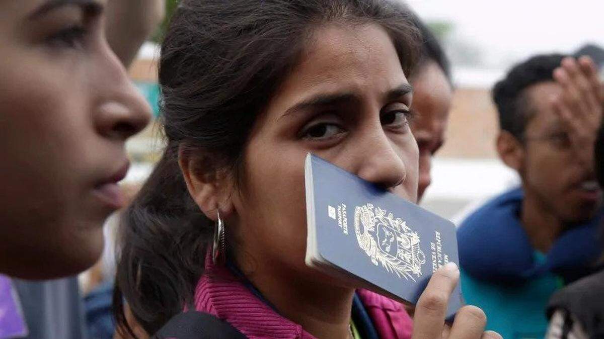 A Venezuelan refugee holds her passport while waiting to board a bus in Tumbes, Peru.