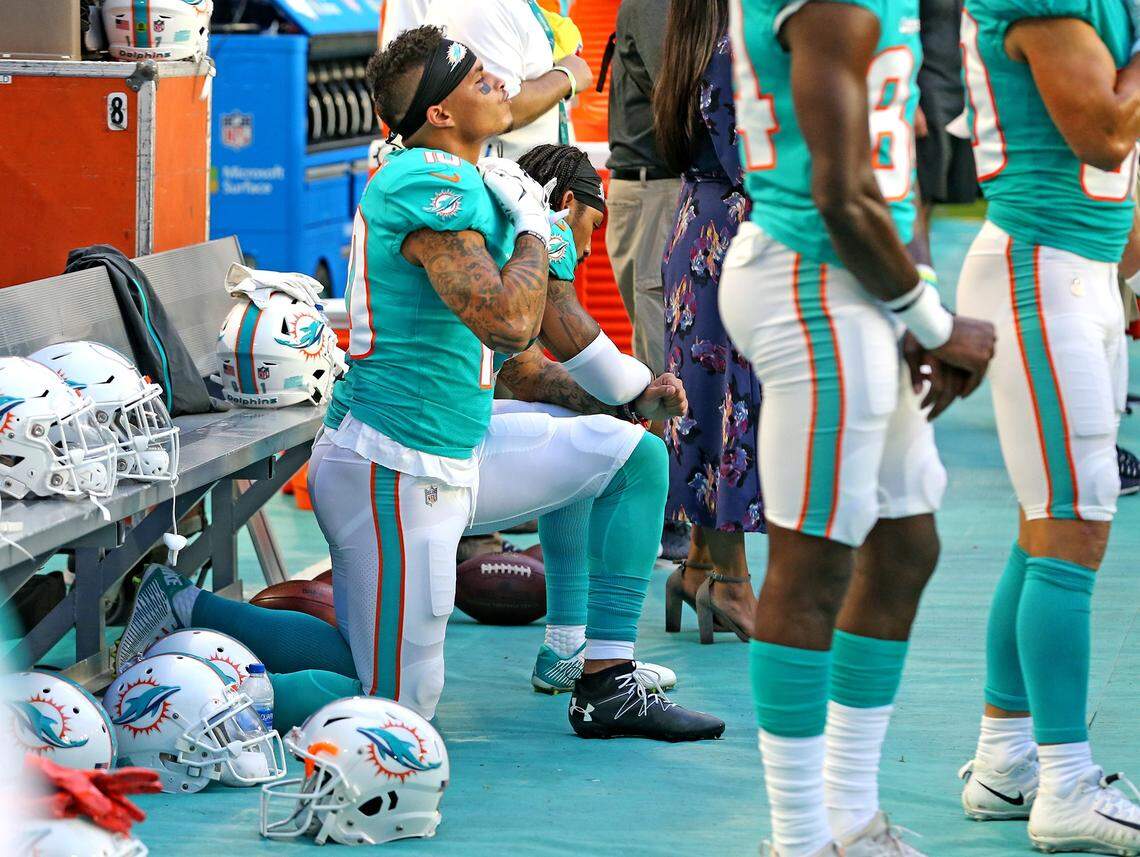 Miami Dolphins receivers Kenny Stills and Albert Wilson kneel during the national anthem as they prepare to play the Tampa Bay Bucs in the preseason opener at Hard Rock Stadium in Miami Gardens, Florida, August 9, 2018. 