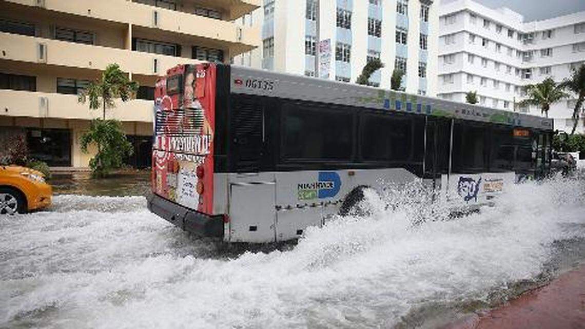 A bus in Miami Beach plows through a street where flooding was caused by the combination of the lunar orbit that caused seasonal high tides and what many believe are rising sea levels spurred by climate change.