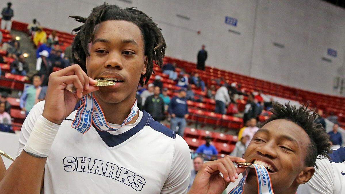 University School Scottie Barnes (32) and Xavien Flowers (10) bite their medals after they defeated Andrew Jackson in the 5A Boy’s Finals State Basketball Championships at the RP Funding Center in Lakeland, Florida, Thursday, March, 7, 2019.