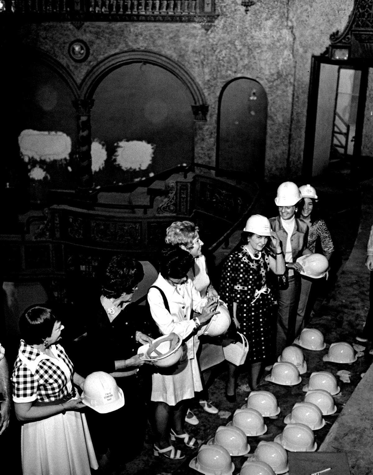 Visitors in hard hats take in a restoration of the Olympia Theater.