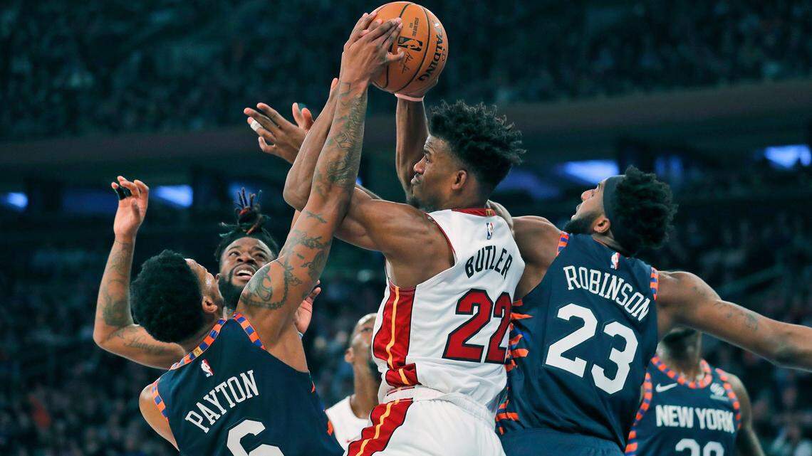 Miami Heat’s Jimmy Butler, center, fights for a rebound during the first half of the NBA basketball game against the New York Knicks, Sunday, Jan. 12, 2020, in New York.
