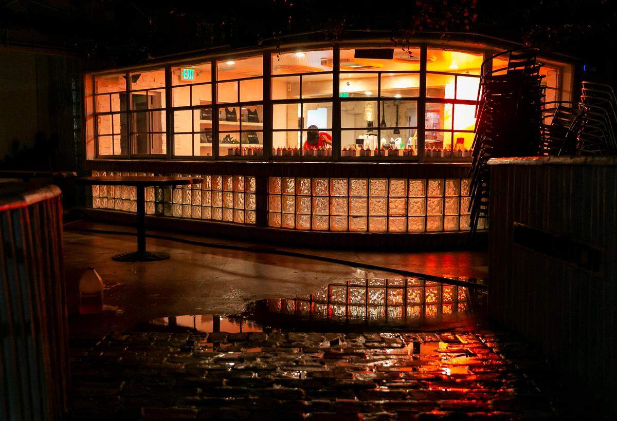 A worker closes shop near Collins Avenue and 10th Street in Miami Beach, Florida on Friday, March 25, 2022. City officials imposed a midnight curfew and forced stores to stop selling alcohol after 6 p.m. The restrictions were set in place after two shootings in Miami Beach the weekend before caused city officials to announce a “state of emergency.”