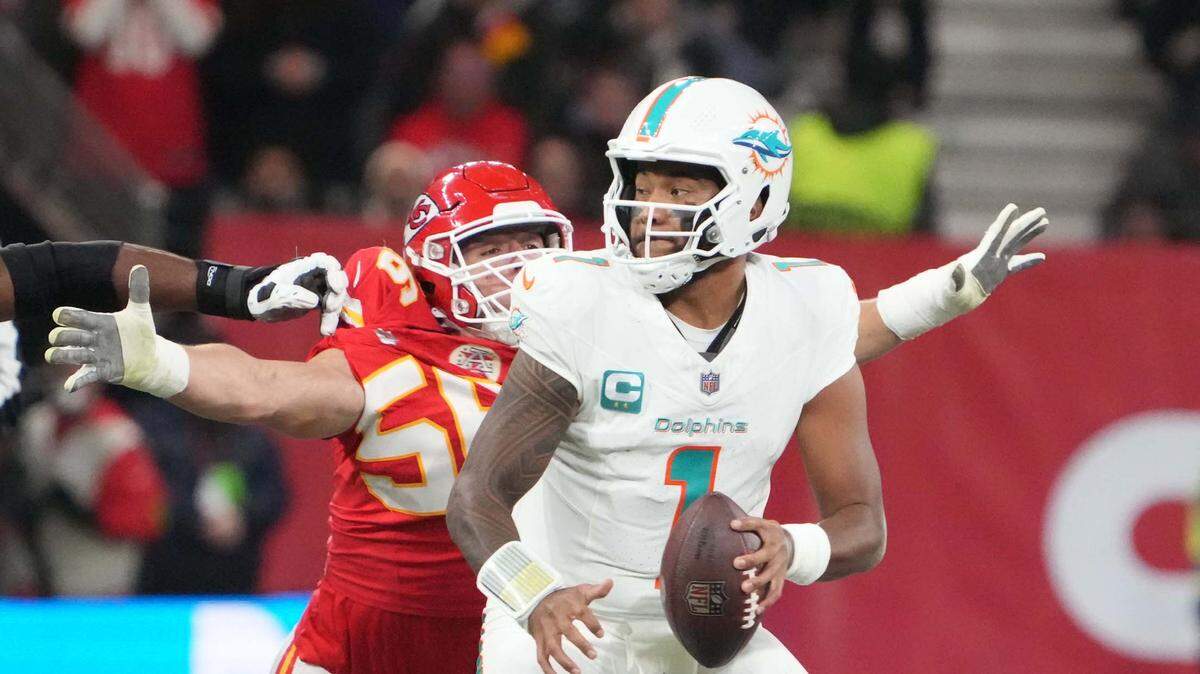 Nov 5, 2023; Frankfurt, Germany; Miami Dolphins quarterback Tua Tagovailoa (1) throws the ball under pressure from Kansas City Chiefs defensive end George Karlaftis (56) in the second half during an NFL International Series game at Deutsche Bank Park. Mandatory Credit: Kirby Lee-USA TODAY Sports