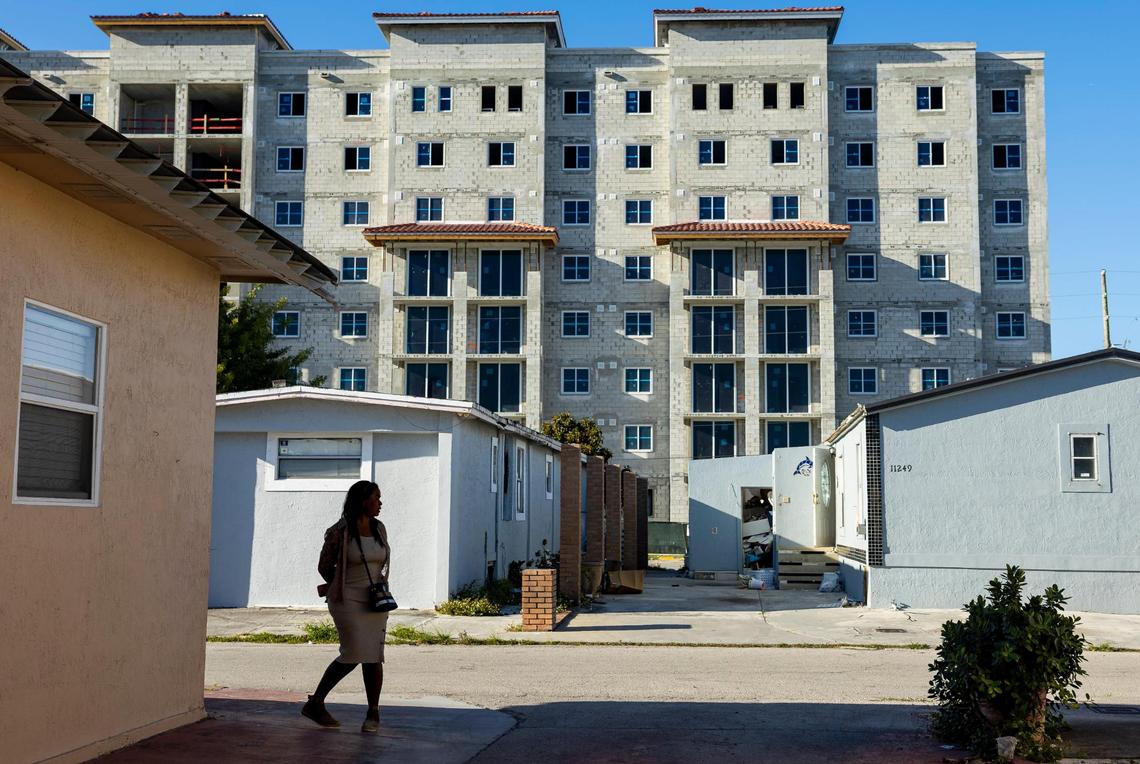 Maria Perebaez, 55, looks on as she visits the Li’l Abner Mobile Home Park on Friday, March 7, 2025, in Sweetwater, Florida. In the background, construction continues on the Li’l Abner III complex.