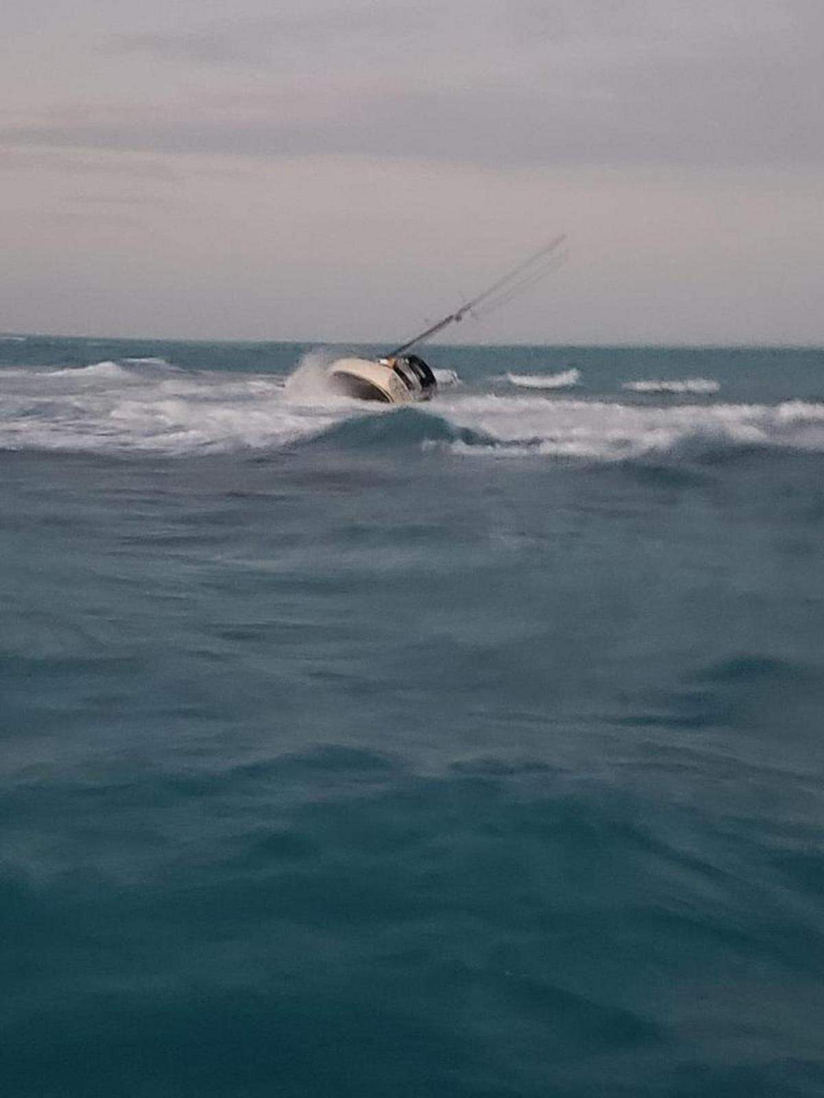 The sailing vessel, No Worries, is shown capsizing Feb. 21, 2019, near Key Largo. A Coast Guard Station Islamorada 45-foot Response Boat-Medium crew and a Coast Guard Air Station Miami MH-65 helicopter crew rescued the two men aboard the boat. Coast Guard Photo by Petty Officer 2nd Class Michael Shortes