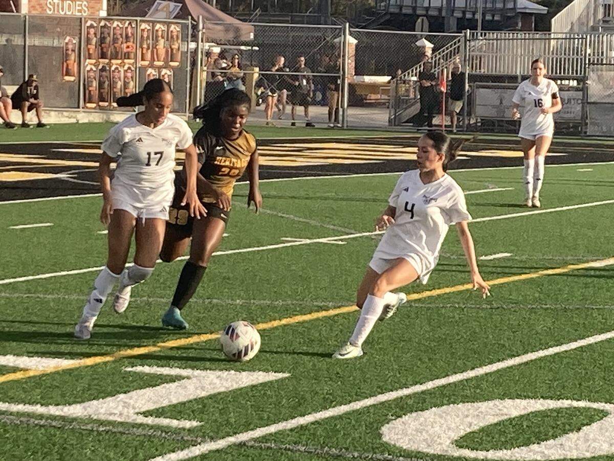 Somerset players Ella Provost-Heron (17) and Hayden Diel Zecca (4) outrace Heritage forward Ariana Doles to a loose ball. Doles scored Heritage’s first goal.