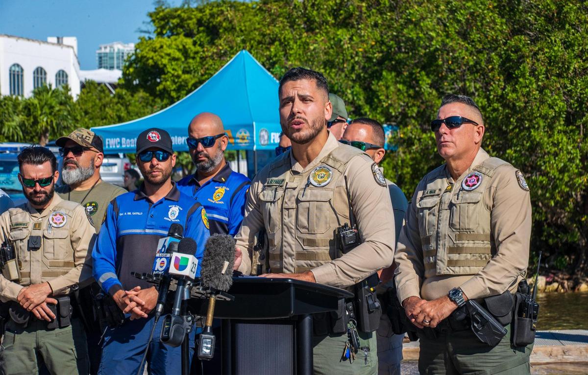 Members of different law enforcement agencies joined FWC spokesperson George Reynaud, as he speaks on the Watson Island Marina area in Miami, during a press event held by the Florida Fish and Wildlife Conservation Commission, along with the city of Miami and Miami-Dade County police departments, to announce a combined effort underway this week to document both derelict vessels in South Florida, and those at risk of becoming derelict, on Tuesday, October 17, 2023.