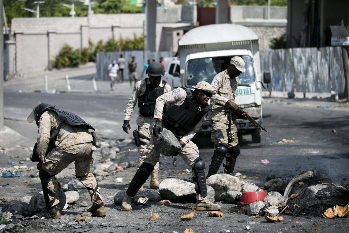Police officers clear a street barricade during a protest against fuel shortages in Port-au-Prince, Haiti, Tuesday, Sept. 17, 2019.