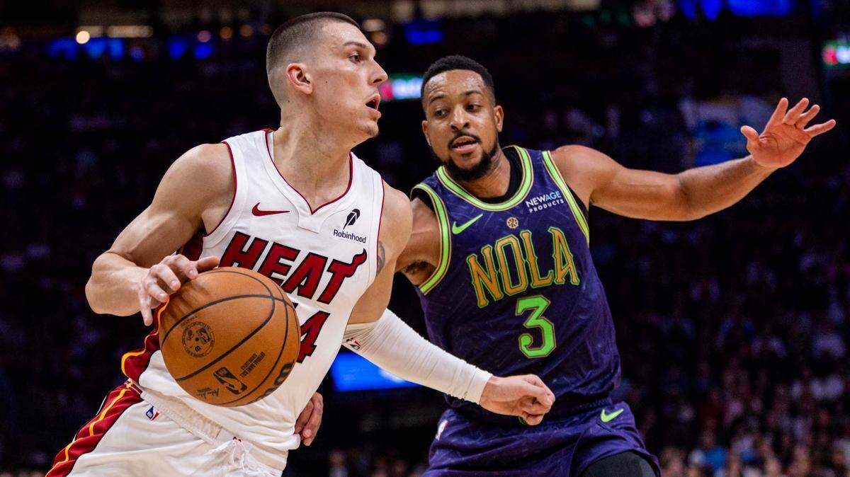 Miami Heat guard Tyler Herro (14) dribbles past New Orleans Pelicans guard CJ McCollum (3) during the second half of an NBA game at Kaseya Center on January 1, 2025, in Miami.