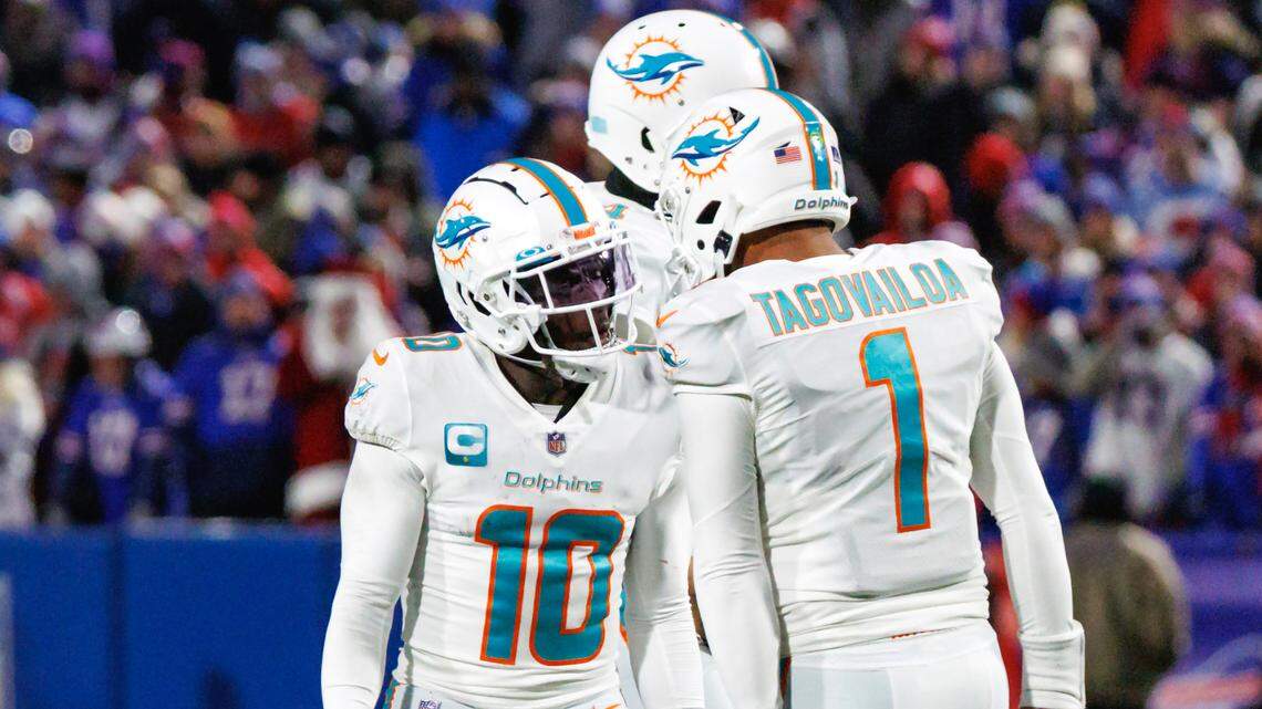 Miami Dolphins wide receiver Tyreek Hill (10) celebrates with teammate Tua Tagovailoa (1) after scoring a touchdown during third quarter of an NFL football game against the Buffalo Bills at Highmark Stadium on Saturday, December 17, 2022 in Orchard Park, New York.