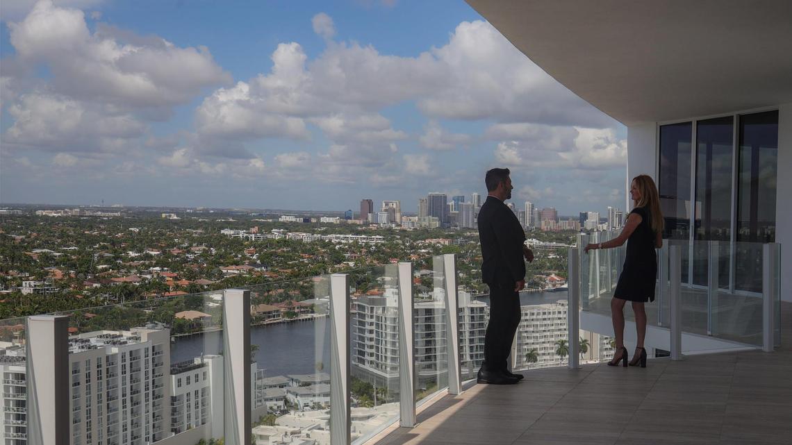 Home sales dropped in both Miami-Dade and Broward counties, yet prices continue to rise to new historic highs. Above: Dan Teixeira, director of sales Douglas Elliman Development Marketing (left) and Julie Jones, VP of ultra luxury sales for Douglas Elliman (right) take in the downtown skyline from a penthouse apartment balcony at the Four Seasons Hotel and Residences in Fort Lauderdale, Florida.