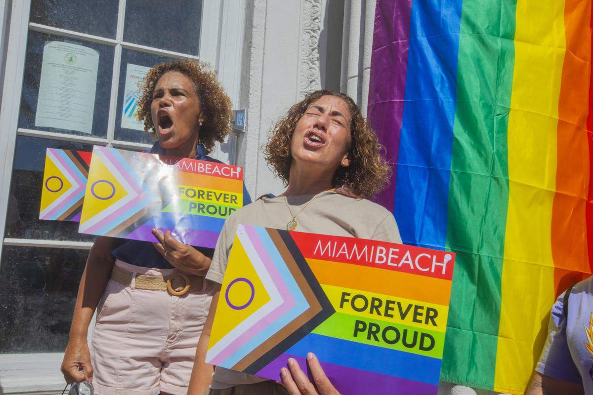 From left, Salome Milan and Lilia Tome rally with other demonstrators carrying rainbow flags and signs reading ‘Miami Beach Forever Proud’ and ‘Won’t Be Erased’ during the Forever Proud March on Ocean Drive in Miami Beach, Fla., Sunday, Aug. 31, 2025. The march followed state officials’ order to remove the city’s LGBTQ Pride crosswalk.