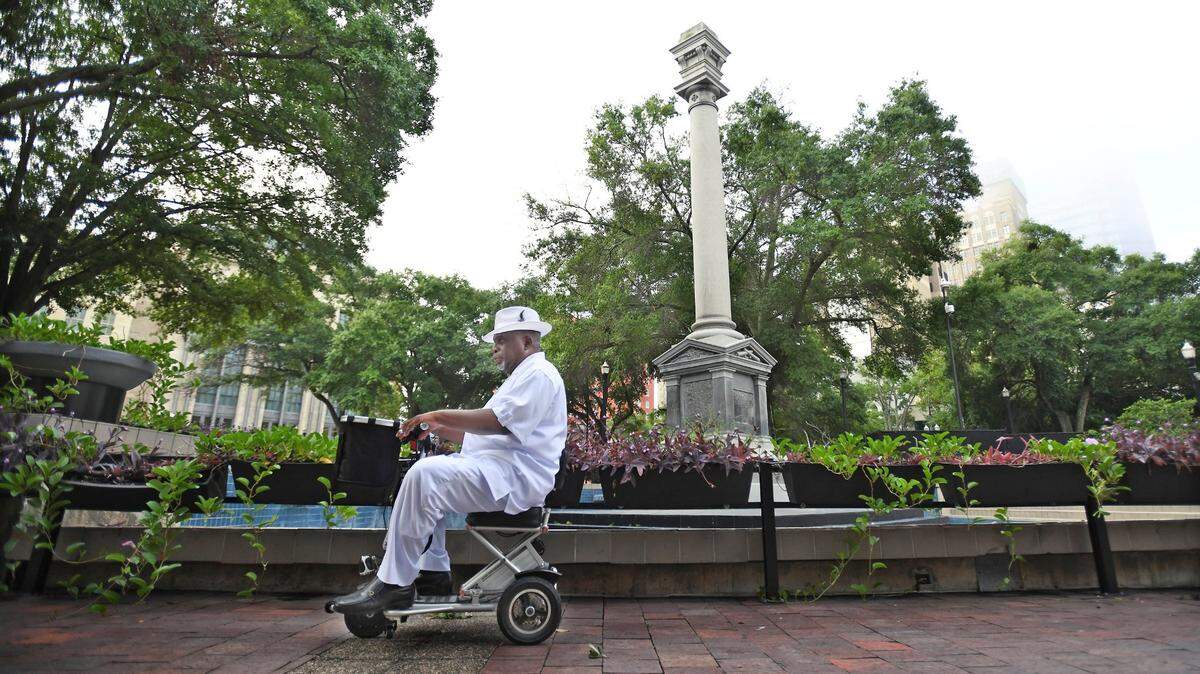 Ben Frazier, fundador y presidente de Northside Coalition de Jacksonville, que organizó gran parte del movimiento para retirar los monumentos confederados en Jacksonville, pasando junto a la columna del monumento confederado parcialmente desmantelado en Hemming Park, el 9 de junio de 2020. El monumento erigido en 1898 había sido parcialmente desmantelado, con la estatua del soldado confederado que lo remataba y las placas de bronce alrededor de la base retiradas esa misma mañana.