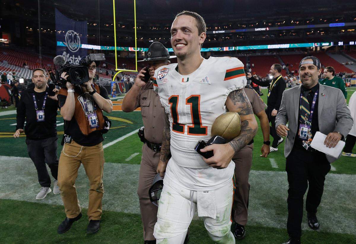 Miami Hurricanes quarterback Carson Beck (11) carries the Offensive MVP Trophy after defeating the Mississippi Rebels during the College Football Playoff semifinal at the Fiesta Bowl in State Farm Stadium on Friday, January 9, 2026 in Glendale, Arizona.