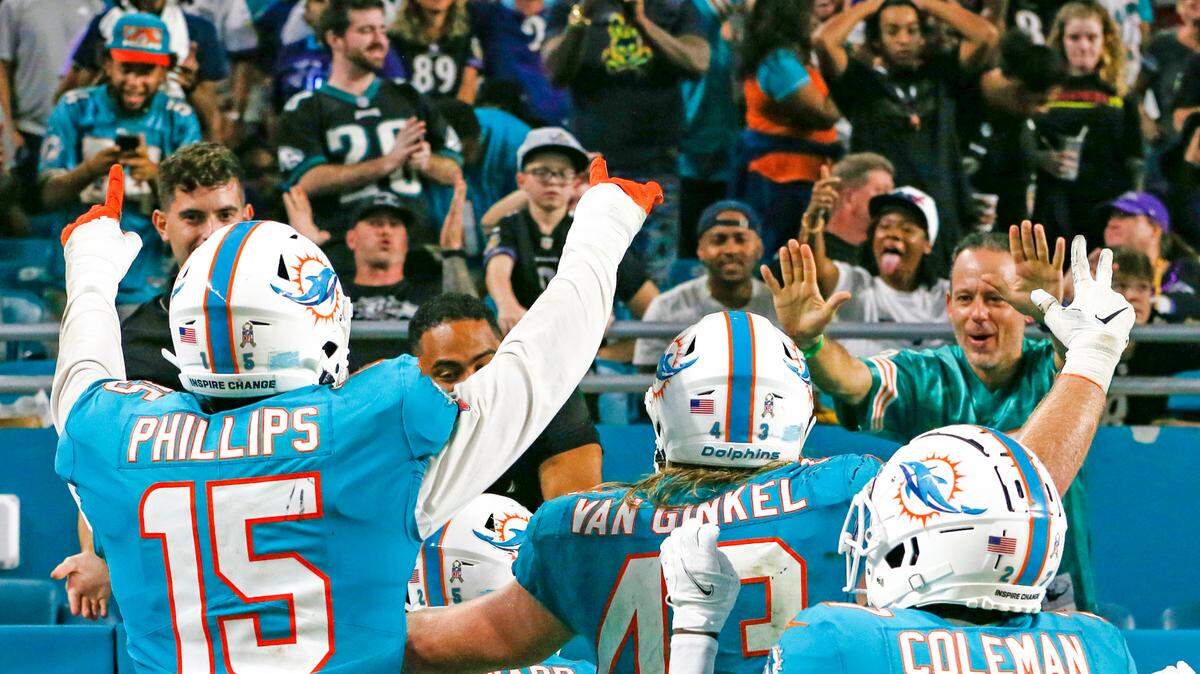 Miami Dolphins cornerback Xavien Howard (25) alongside teammates celebrate with fans after scoring recuperating a fumble by Baltimore Ravens wide receiver Sammy Watkins (14) during the fourth quarter of an NFL football game at Hard Rock Stadium on Thursday, November 11, 2021 in Miami Gardens, Florida.