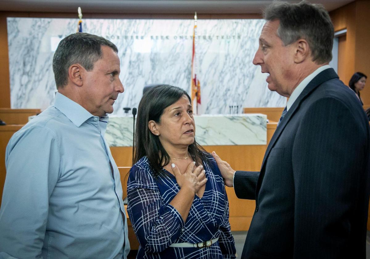 Pablo and Andrea Langesfeld, parents of Nicole “Nicky” Langesfeld, who died in the collapse, speak to the court appointed receiver, Michael Goldberg, right, after court proceedings. In a surprise development, the class-action litigation over the collapse of Champlain Towers South has been settled, a judge was told Wednesday, May 11, 2022, with plaintiffs expected to receive just under $1 billion.
