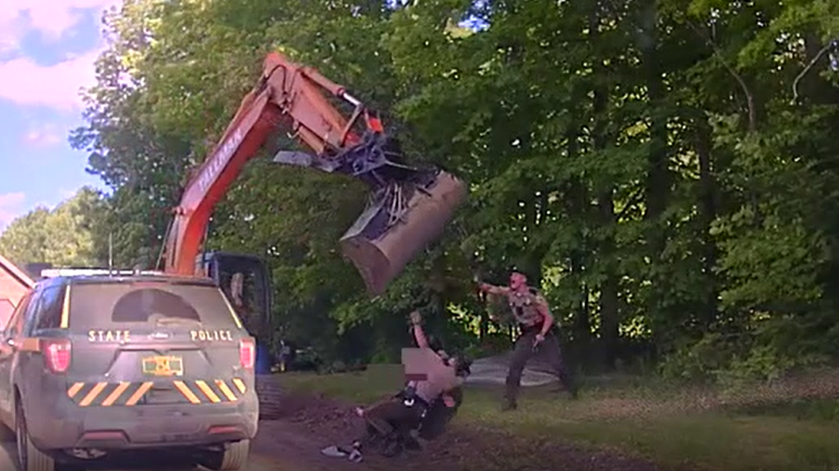 A Vermont man attacked state troopers with an excavator outside his home, police say.