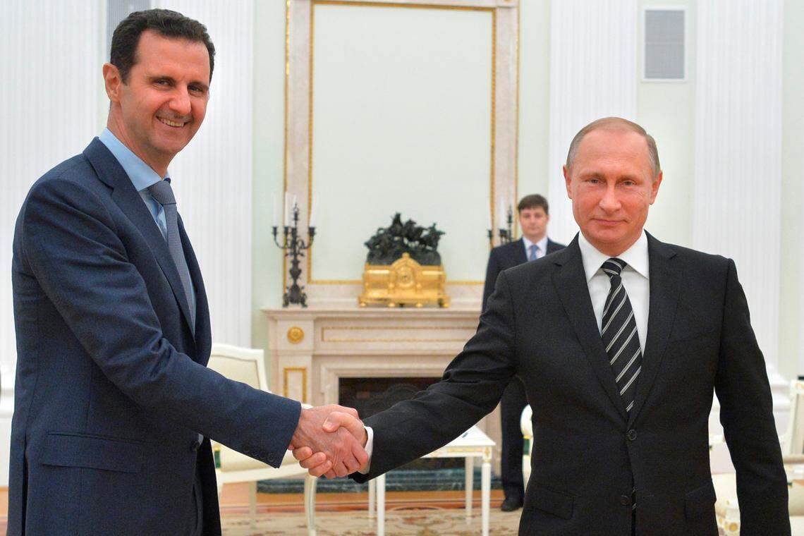 FILE - In this Tuesday, Oct. 20, 2015 file photo, Russian President Vladimir Putin, right, shakes hand with Syria President Bashar Assad in the Kremlin in Moscow, Russia. (Alexei Druzhinin, RIA-Novosti, Kremlin Pool Photo via AP, File)
