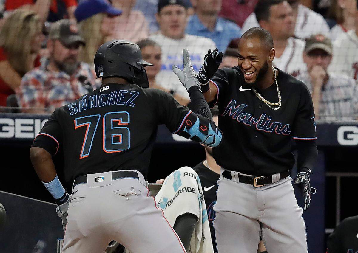 Miami Marlins’ Jesus Sanchez (76) and Bryan De La Cruz celebrate their back to back home runs off Atlanta Braves’ Richard Rodriguez in the eighth inning of a baseball game Saturday, Sept. 11, 2021, in Atlanta.