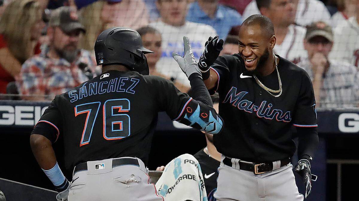 Miami Marlins’ Jesus Sanchez (76) and Bryan De La Cruz celebrate their back to back home runs off Atlanta Braves’ Richard Rodriguez in the eighth inning of a baseball game Saturday, Sept. 11, 2021, in Atlanta.