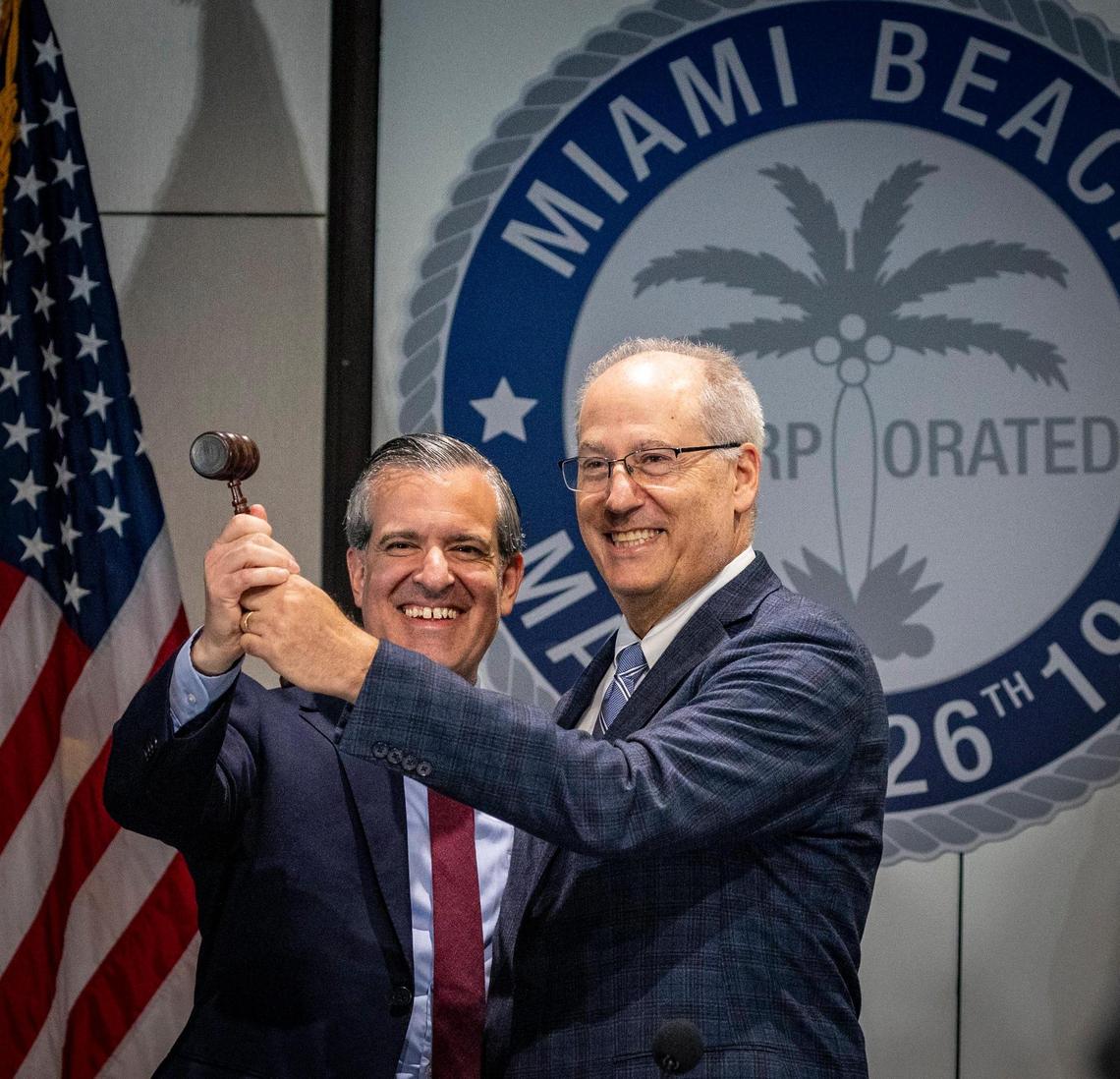 Newly sworn Miami Beach Mayor Steven Meiner, left, takes the gavel from outgoing Mayor Dan Gelber during a ceremony at the Miami Beach Convention Center, Tuesday, November 28, 2023.
