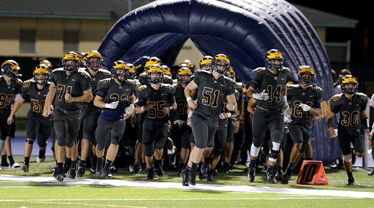 Belen players come out to the field during the Belen Jesuit Preparatory School vs Miami Palmetto Varsity high school football game at Tropical Park on Thursday, November 08, 2018.