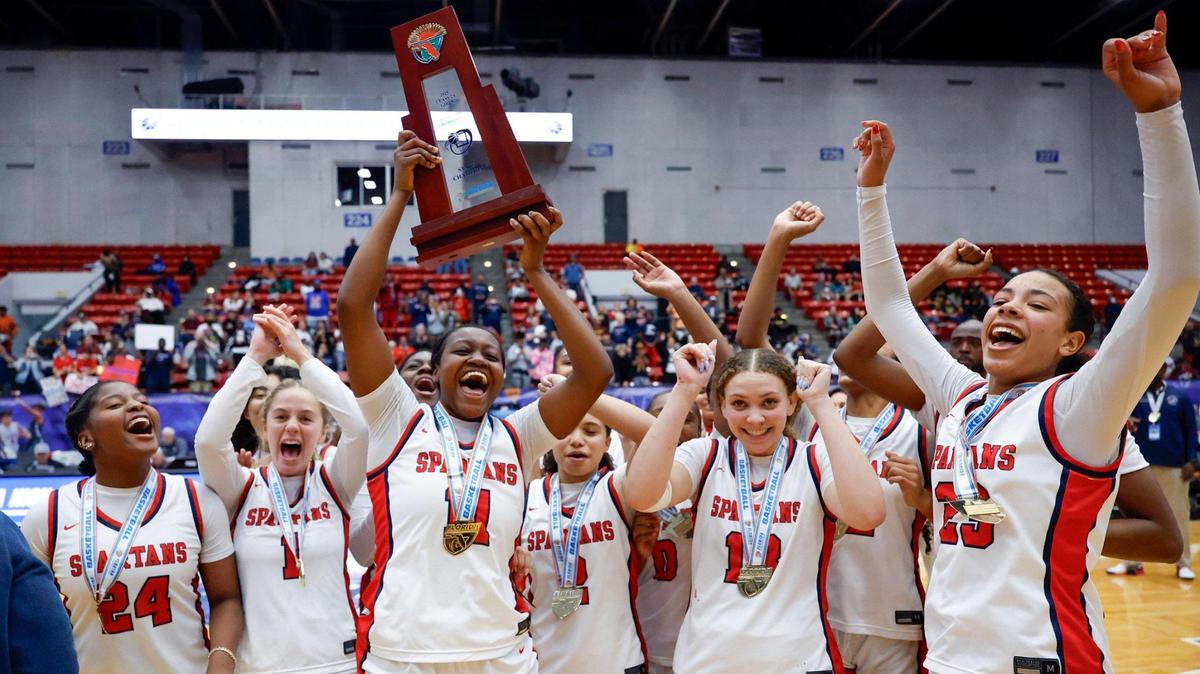 Miami Country Day’s Jada Johnson (11) lifts the state championship trophy after defeating Providence School for the FHSAA Class 2A Girls High School Basketball State Championship at the RP Funding Center in Lakeland, Florida on Saturday, March 1, 2025.