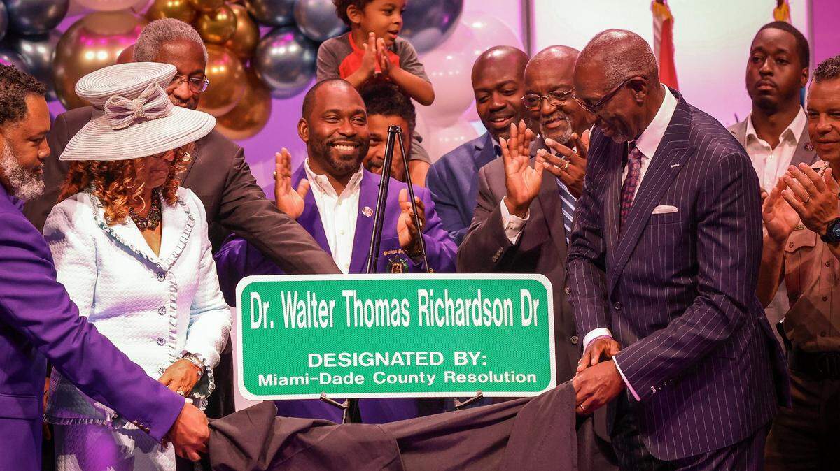 M. Dolores Richardson, left, assists her husband Dr. Walter Thomas Richardson, right, with the unveiling of the street sign that bears his name. On Sunday, June 4, 2023 Miami-Dade Commissioner Kionne L. McGhee hosted a street naming ceremony to honor community leader Dr. Walter Thomas Richardson at Sweet Home Missionary Baptist Church, 10701 SW 184th St., Miami. See item below..