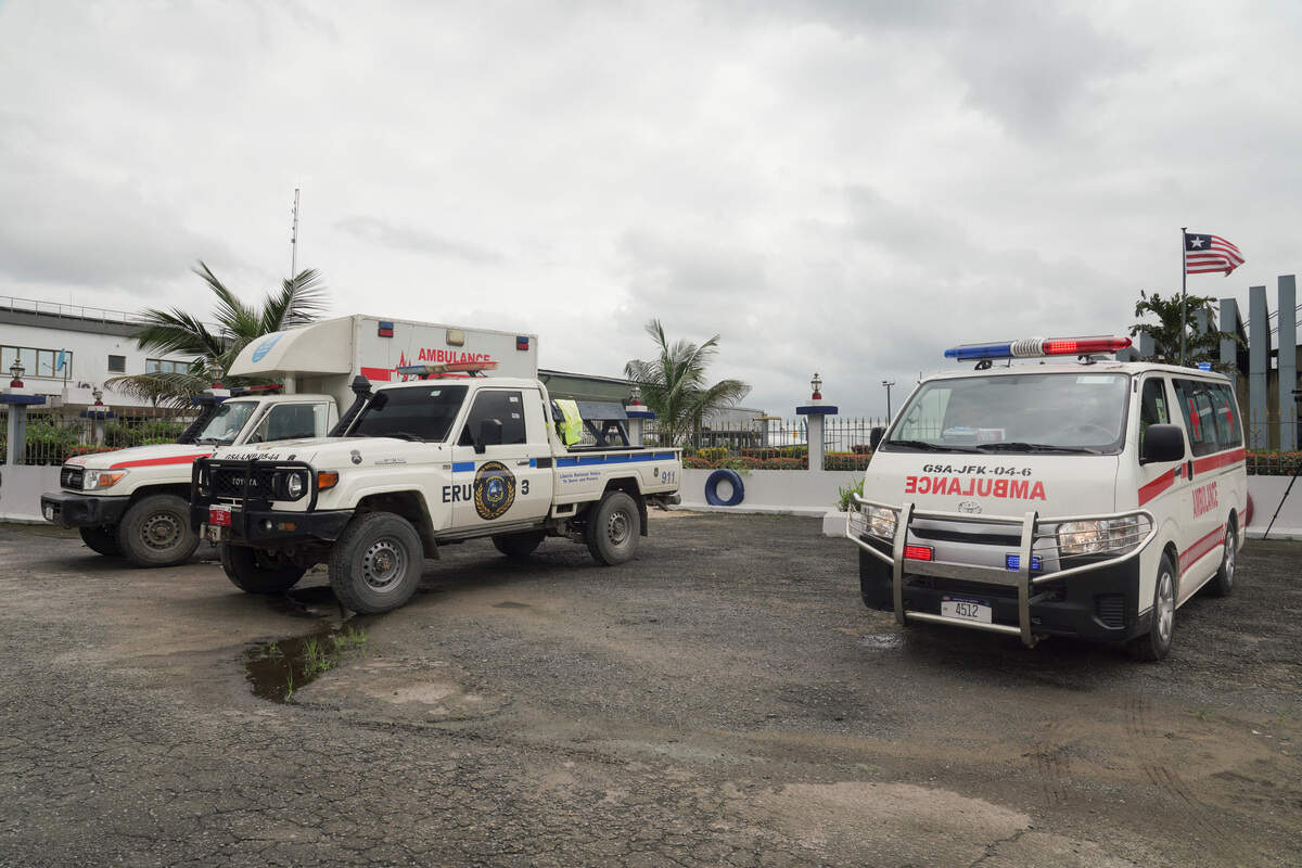 Ambulances and a police vehicle are parked near Roberts International Airport as deportees from the United States arrive at the airport, in Harbel, near Monrovia, Liberia, August 20, 2026.