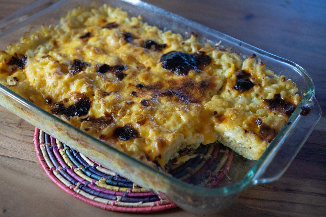 Mac and cheese in a casserole dish with a serving scooped out.