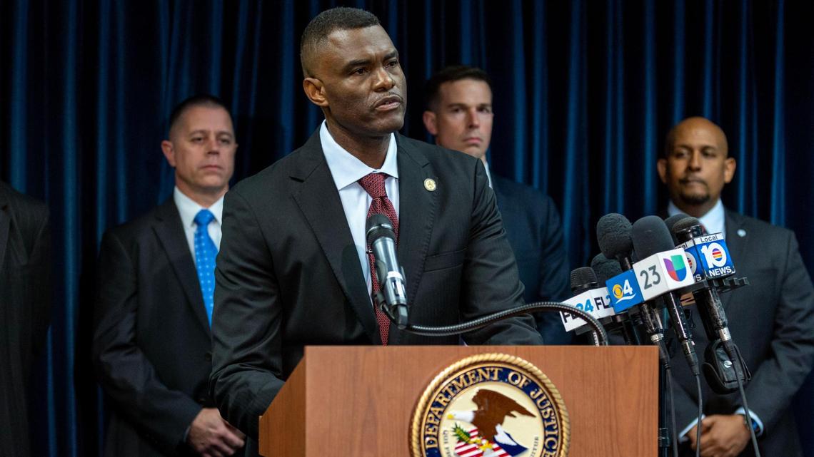 U.S. Attorney Markenzy Lapointe speaks to the media about a network of nursing school operators, centered in South Florida, who allowed students to buy diplomas without the proper training as representatives from FBI Miami and Department of Health and Human Services Office of Inspector General (HHS-OIG), Miami Regional Office. stand behind him during a press conference at the U.S. Attorney’s Office for the Southern District of Florida in Downtown Miami, Florida, on Wednesday, Jan. 25, 2023.