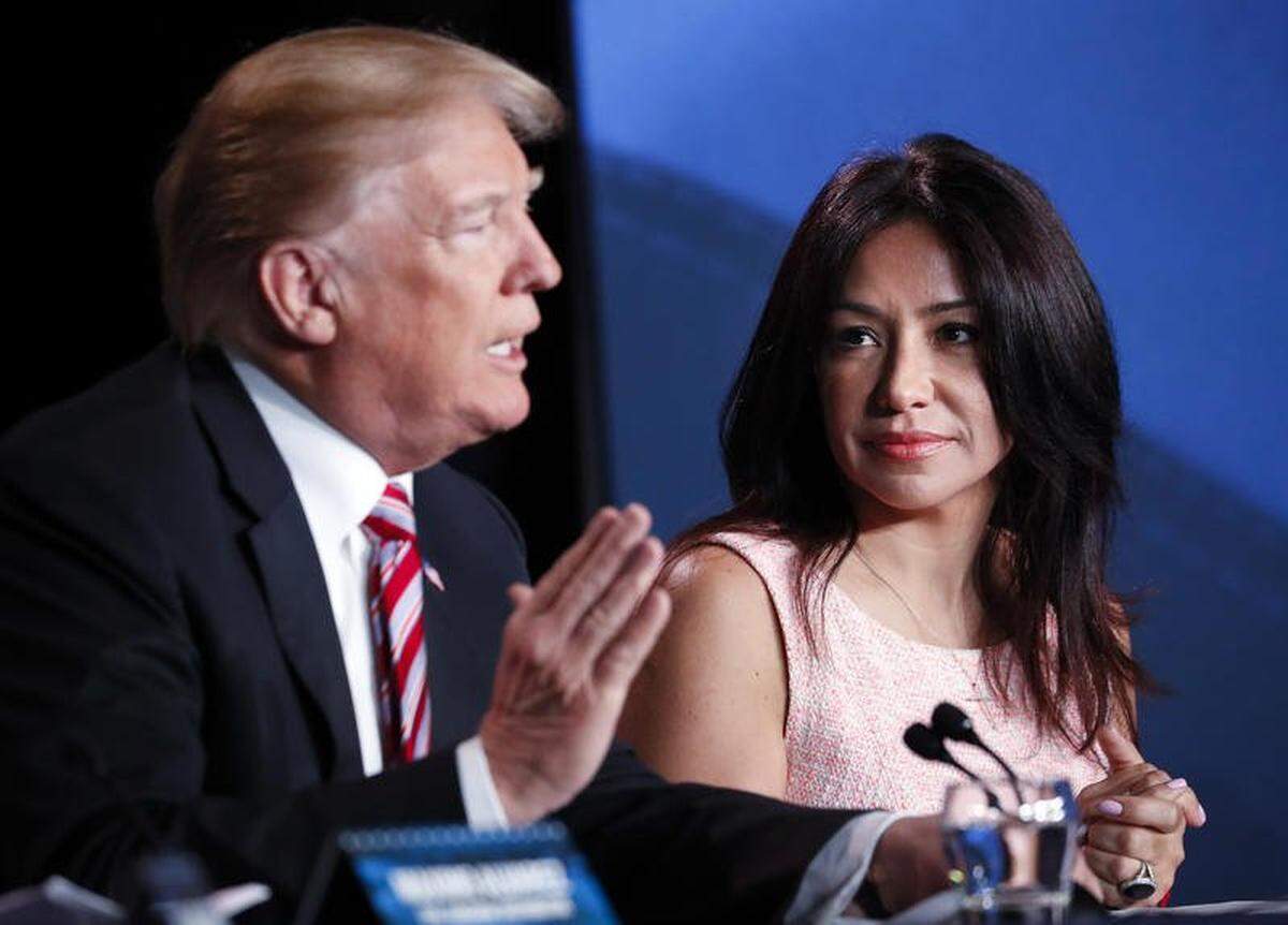 President Donald Trump speaks at an event to promote his $1.5 trillion tax cut package at Bucky Dent Park in Hialeah, Fla., Monday, April 16, 2018, as Irina Vilarino, owner of Las Vegas Cuban Cuisine listens.