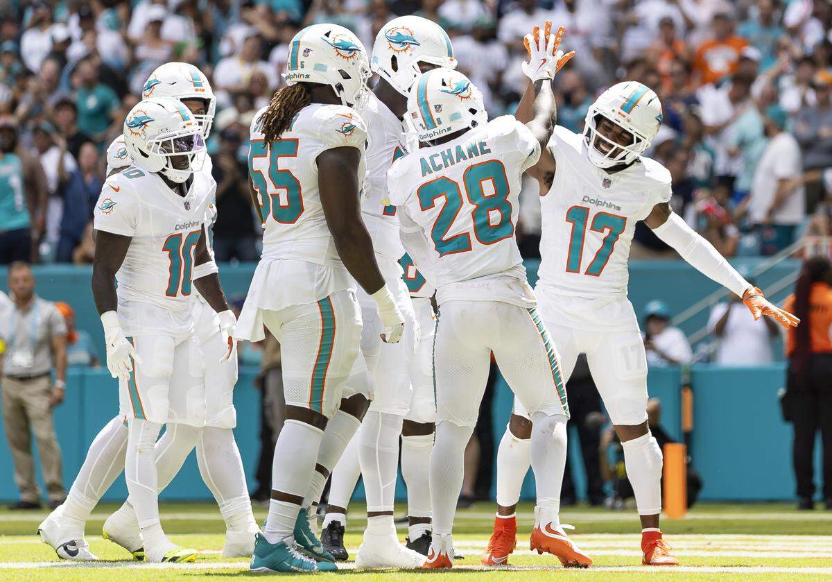 Miami Dolphins running back De'Von Achane (28) celebrates with wide receiver Jaylen Waddle (17) after he scored against the New England Patriots in the first half of their NFL game at Hard Rock Stadium on Sunday, Sept. 14, 2025, in Miami Gardens, Fla.