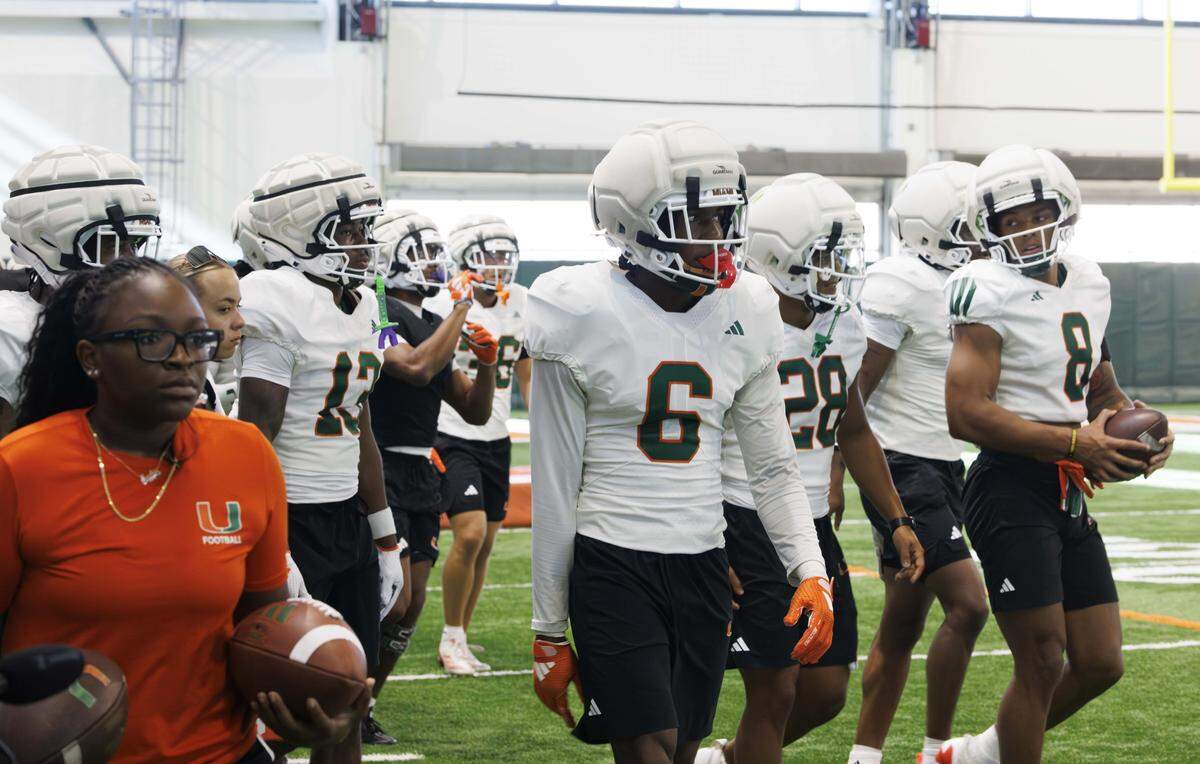 Xavier Lucas (6) and the other defensive backs walk onto the field during Miami Hurricanes football practice on Monday, Aug. 4, 2025, at University of Miami in Coral Gables, Fla.