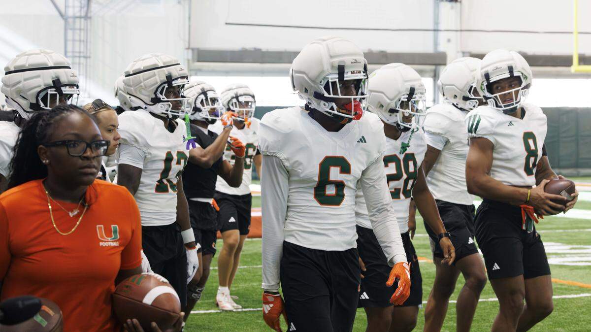 Xavier Lucas (6) and the other defensive backs walk onto the field during Miami Hurricanes football practice on Monday, Aug. 4, 2025, at University of Miami in Coral Gables, Fla. 