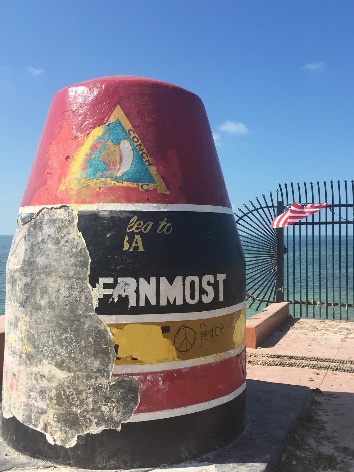 En esta foto de septiembre de 2017 se observan los daños sufridos por la boya original tras el paso de los vientos y las fuertes lluvias del huracán Irma por esta popular atracción. Los artistas originales la repararon en menos de un mes. Tras su remodelación, conserva su encanto pintoresco, pero el terreno donde se encuentra será reparado en el otoño de 2025.