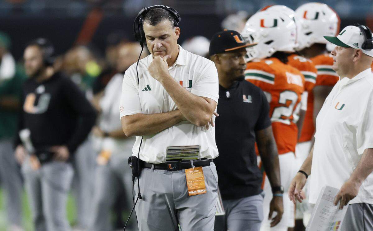 Miami Hurricanes head coach Mario Cristobal walks the sidelines late in the fourth quarter during the game against the Louisville Cardinals of their NCAA football game at Hard Rock Stadium in Miami Gardens, Florida, on Friday, October 17, 2025.