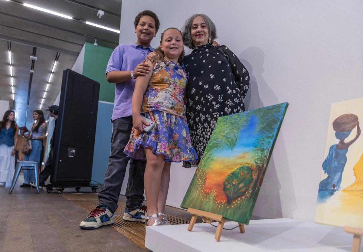 Artist Mirna de los Santos posed with her grandchildren Mila and Jacob, next to her piece on display during the PAMM Creative Aging Series: Spring Painting Showcase at the Pérez Art Museum Miami, on Saturday May 03, 2025.