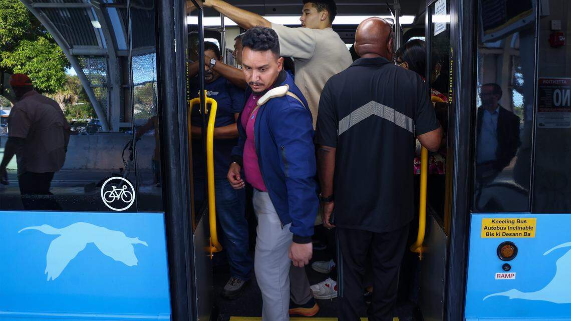 Metro Express commuter Gabriel Moreno, 37, center, exits the crowded bus in favor of empty bus as he makes his way to work on the first day of Miami-Dade's $300 million rapid-transit bus line known as “Metro Express” on Monday, October 27, 2025, just west of Richmond Heights on Coral Reef Drive and U.S. 1. Many first day riders complained about crowded buses and long travel times due to red lights on the express lane.