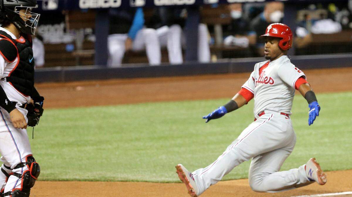 Miami Marlins catcher Jorge Alfaro (38) waits a home plate as Philadelphia Phillies Jean Segura (2) slides to score in the fourth inning at loanDepotpark in Miami, Florida, May 26, 2021.
