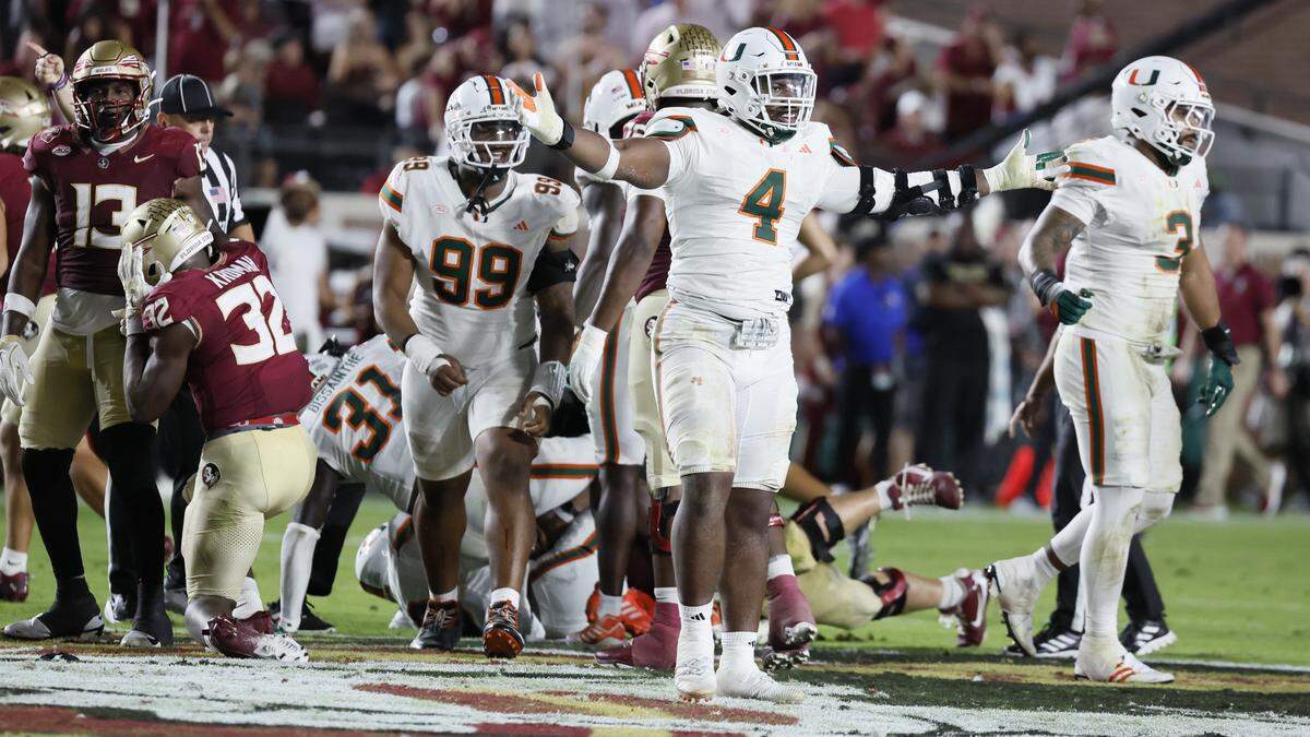 Miami Hurricanes defensive lineman Rueben Bain Jr. (4) and defensive lineman Ahmad Moten Sr. (99) react after defensive back Keionte Scott (0) recovers a fumble in the first half against the Florida State Seminoles at Doak Campbell Stadium in Tallahassee, Florida, on Saturday, October 4, 2025.